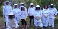 groupe de stagiaires en combinaison d'apiculteur